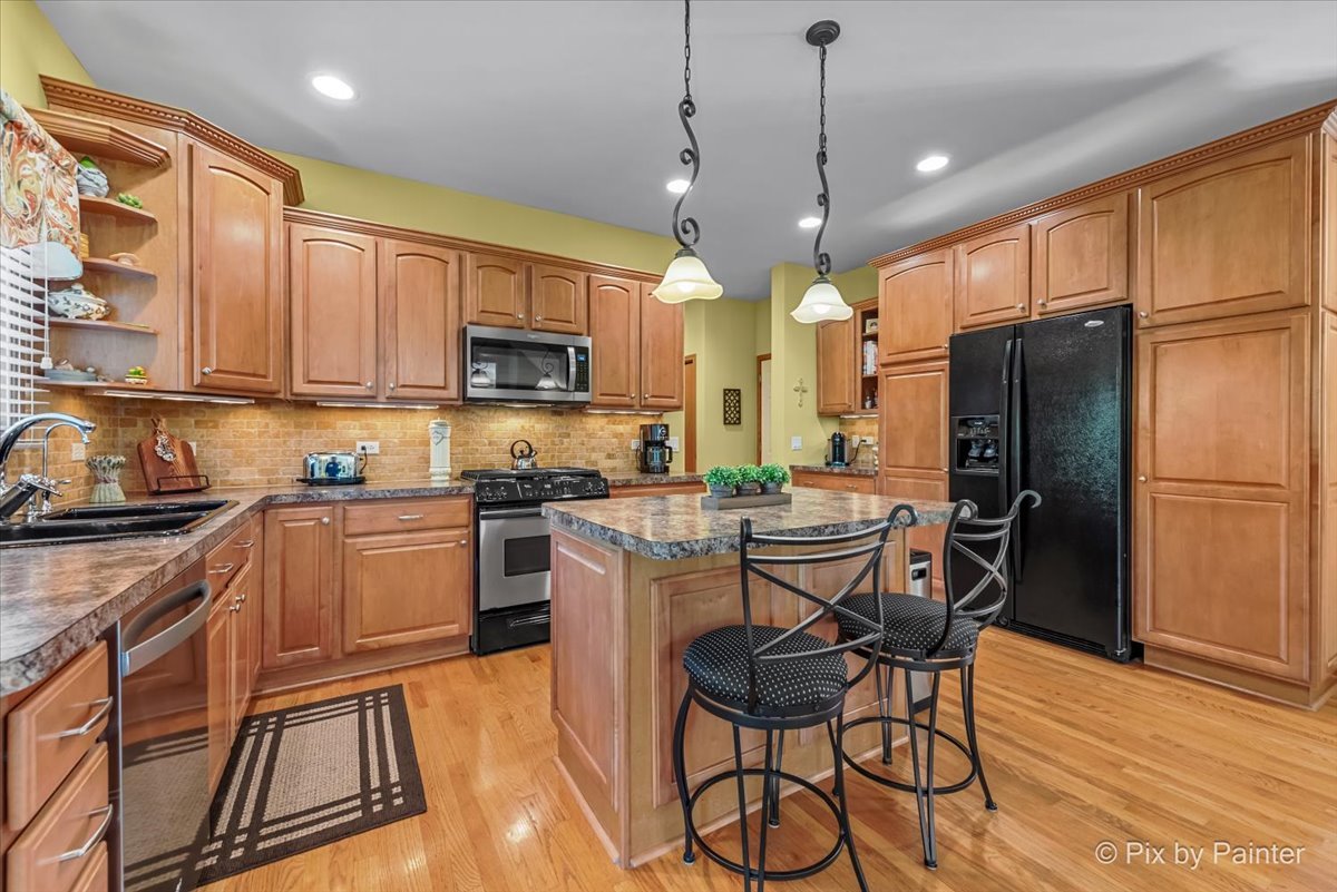 3720 Cypress Drive Spring Grove, IL 60071 - Photo 3 of 55 a kitchen with stainless steel appliances granite countertop a refrigerator a stove top oven a sink dishwasher and white cabinets with wooden floor