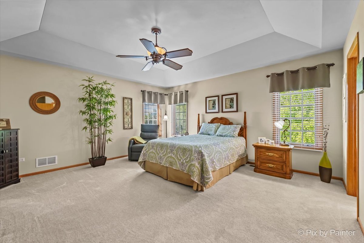 3720 Cypress Drive Spring Grove, IL 60071 - Photo 7 of 55 a spacious bedroom that has a bed and a chandelier