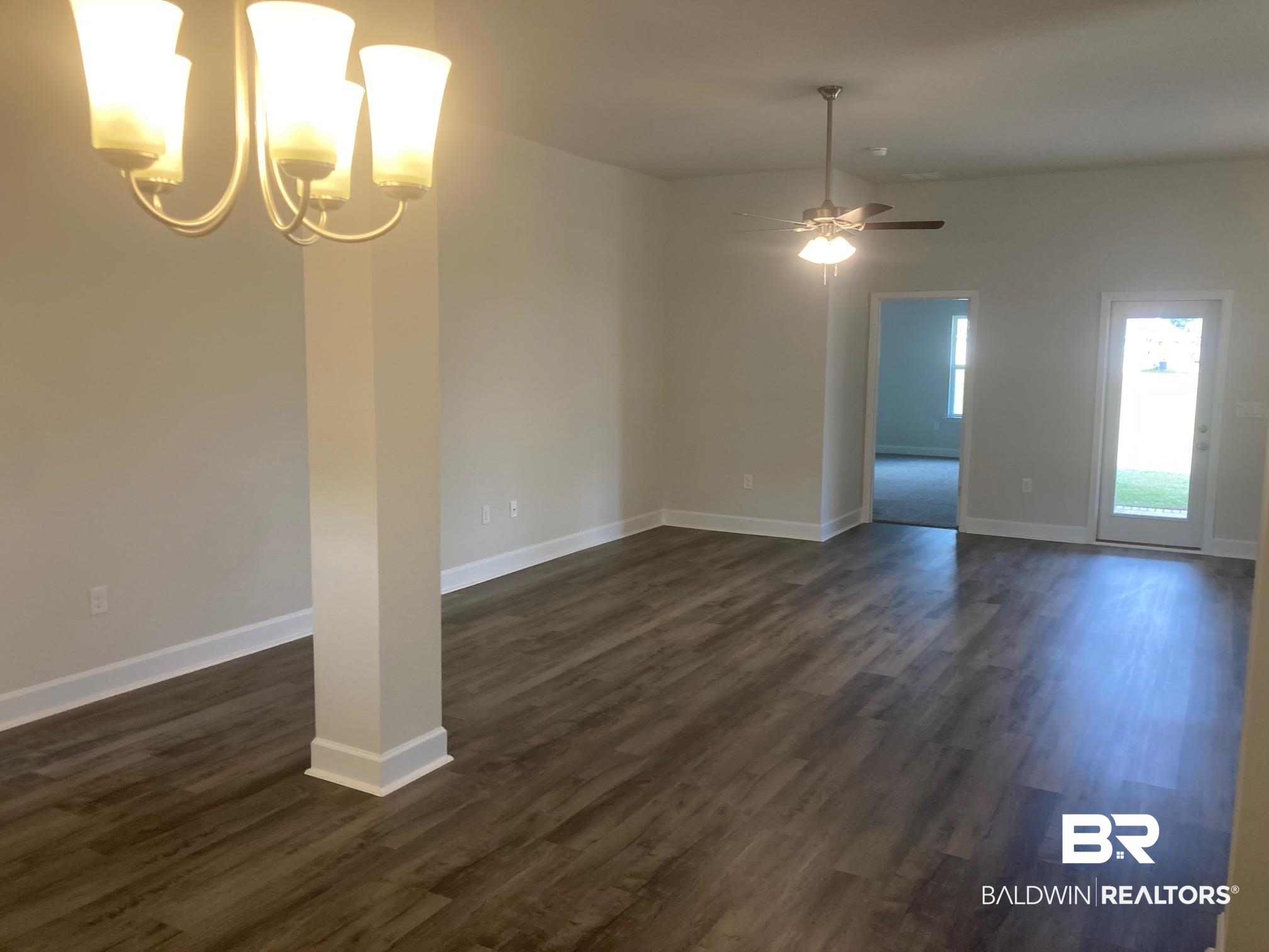 629 Revere Street Foley, AL 36535 - Photo 5 of 30 Empty room with ceiling fan with notable chandelier and dark hardwood / wood-style flooring