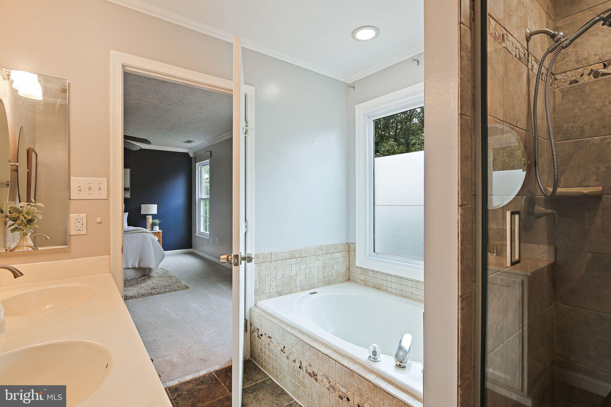 322 Timberbrook Court Odenton, MD 21113 - Photo 18 of 31 a bathroom with a tub a mirror and a shower