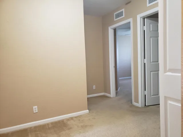 an empty room with closet and mirror