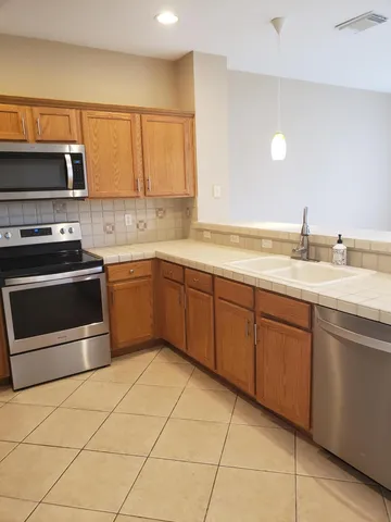 a kitchen with stainless steel appliances granite countertop a sink and a stove