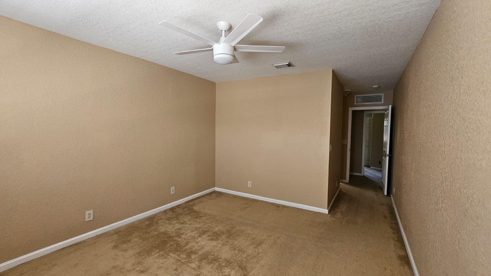 3027 North Evergreen Circle, Unit 3027 Boynton Beach, FL 33426 - Photo 22 of 35 an empty room with a ceiling fan and a window