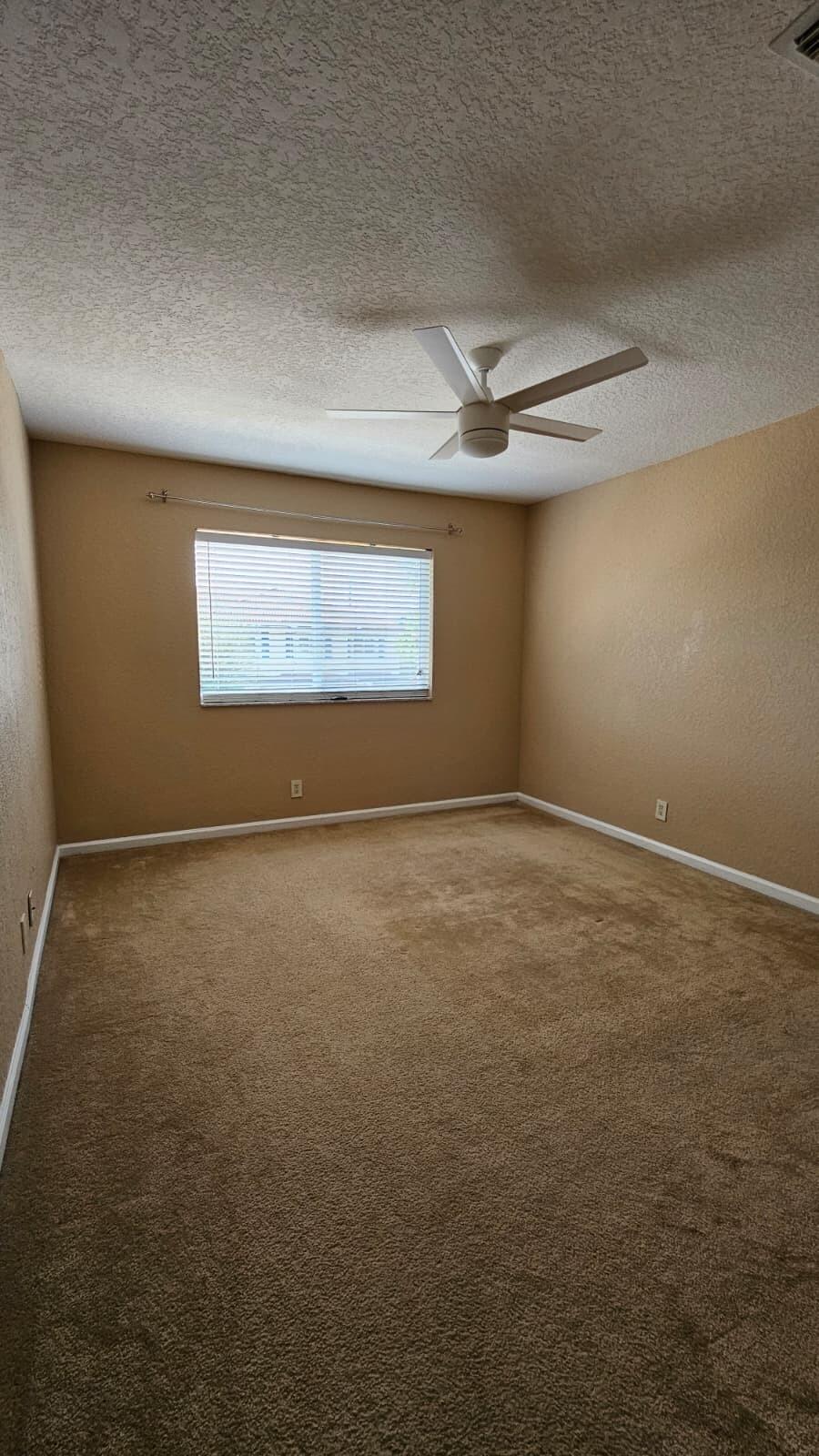 3027 North Evergreen Circle, Unit 3027 Boynton Beach, FL 33426 - Photo 23 of 35 en empty room with windows and ceiling fan