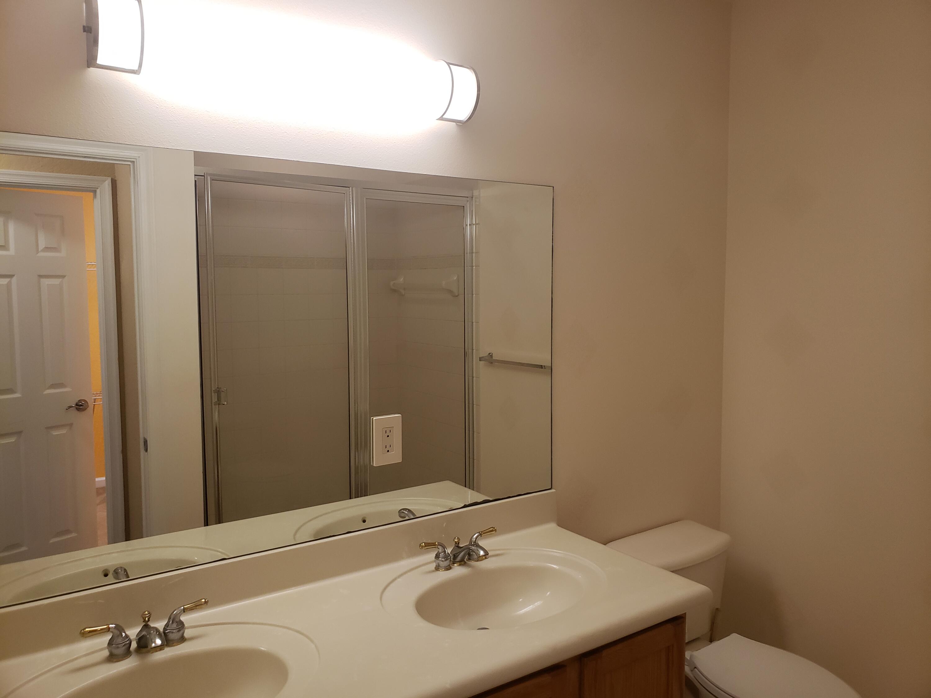 3027 North Evergreen Circle, Unit 3027 Boynton Beach, FL 33426 - Photo 25 of 35 a bathroom with a sink and a mirror