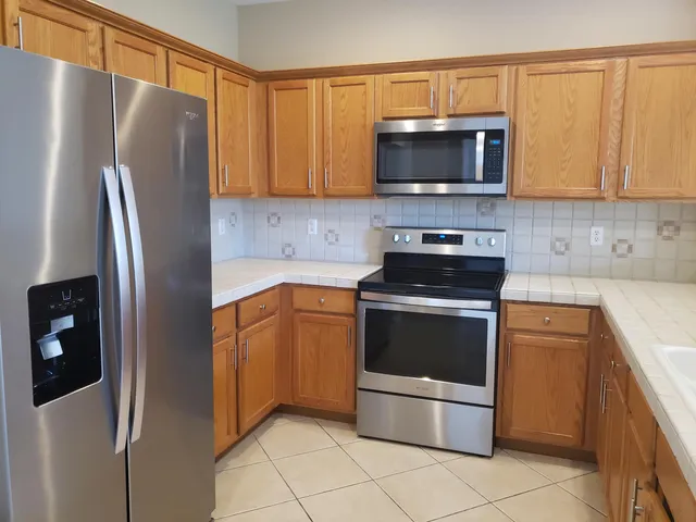 a kitchen with stainless steel appliances granite countertop a refrigerator stove and microwave