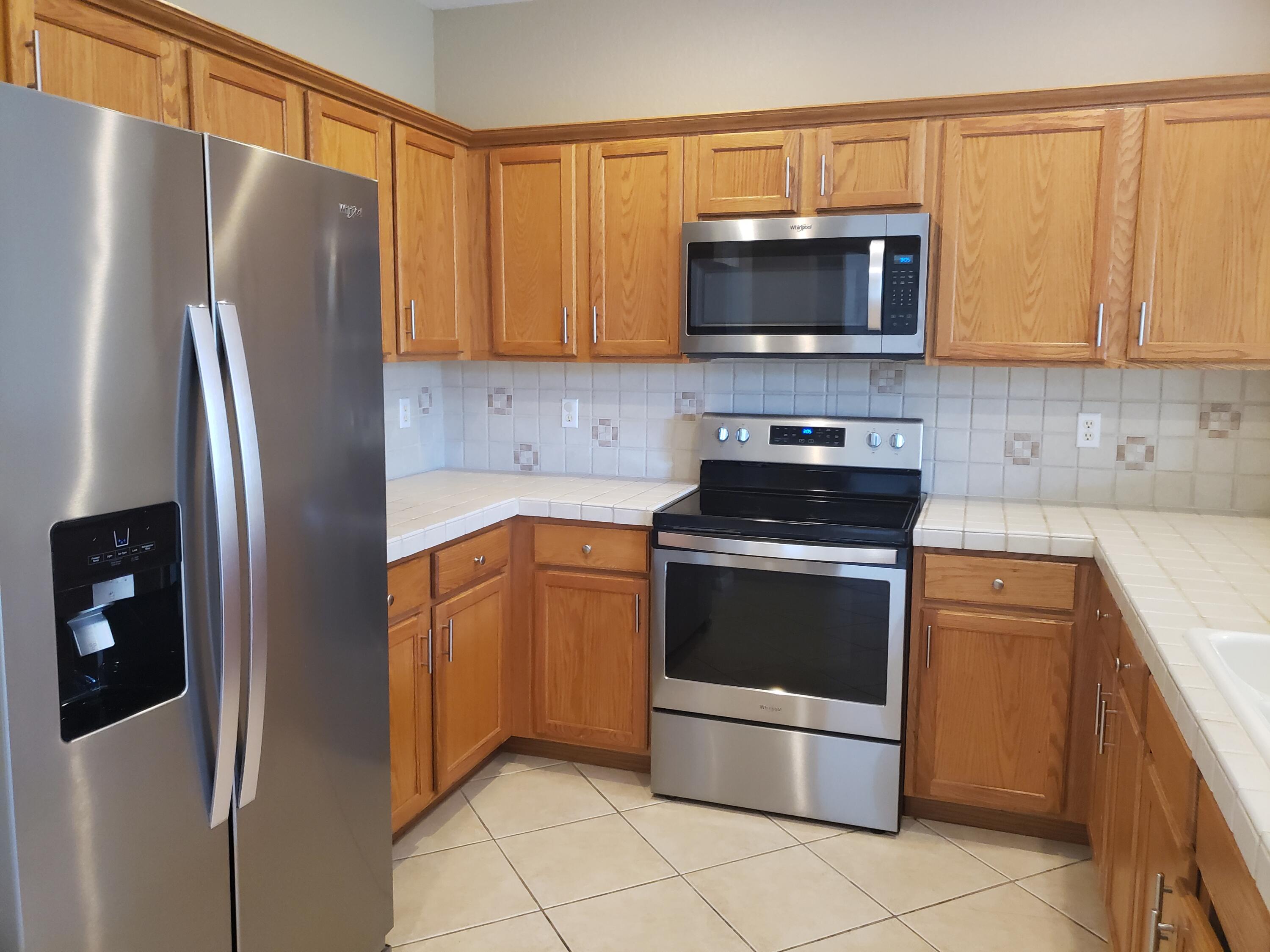 3027 North Evergreen Circle, Unit 3027 Boynton Beach, FL 33426 - Photo 3 of 35 a kitchen with stainless steel appliances granite countertop a refrigerator stove and microwave