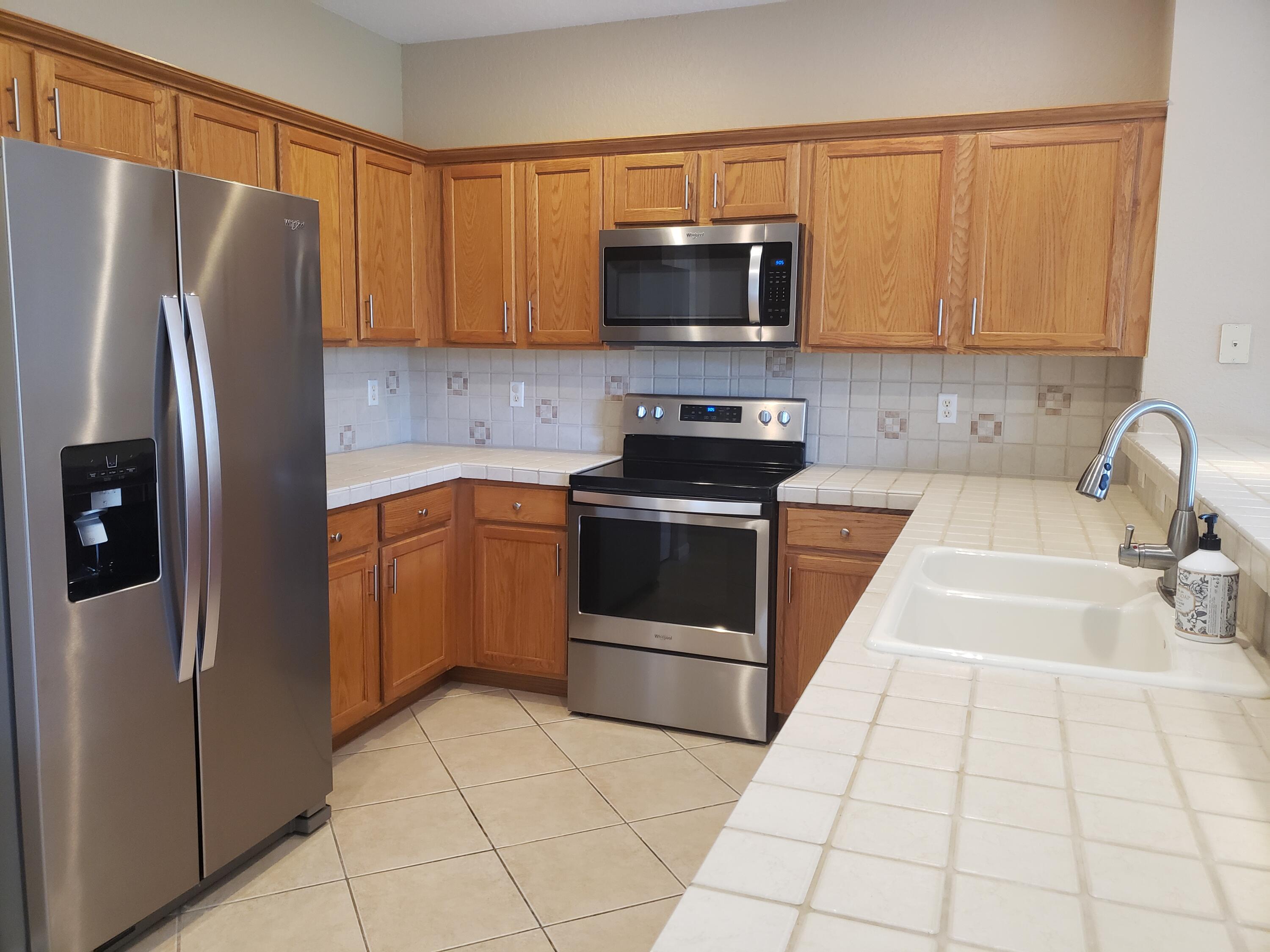 3027 North Evergreen Circle, Unit 3027 Boynton Beach, FL 33426 - Photo 6 of 35 a kitchen with stainless steel appliances a refrigerator sink and microwave
