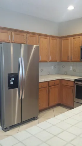 a kitchen with stainless steel appliances granite countertop a refrigerator and a stove