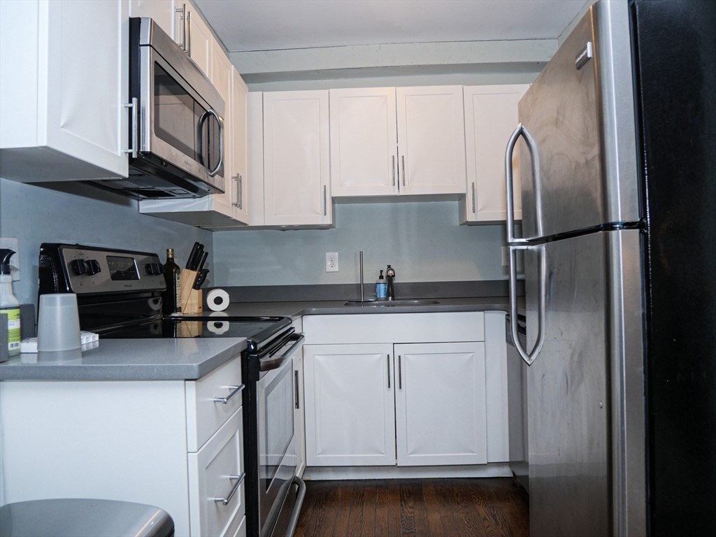 45 Carlton Street, Unit 9 Brookline, MA 02446 - Photo 4 of 8 a kitchen with stainless steel appliances granite countertop a refrigerator sink and cabinets