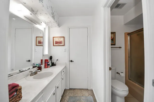 a bathroom with a double vanity sink toilet and shower