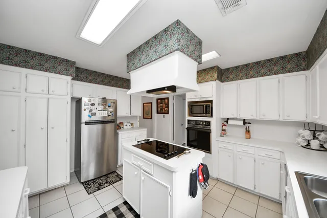 a kitchen with a refrigerator and white cabinets