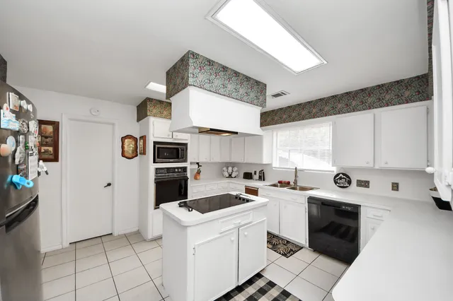 a kitchen with granite countertop a stove top oven and cabinets