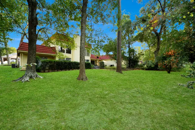 a view of a backyard with table and chairs and a large tree