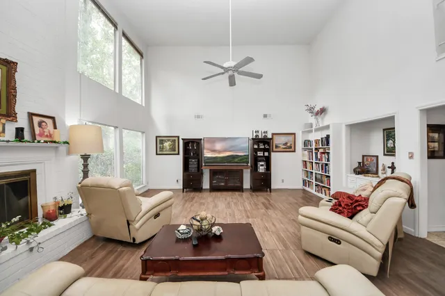 a living room with furniture a fireplace and a flat screen tv