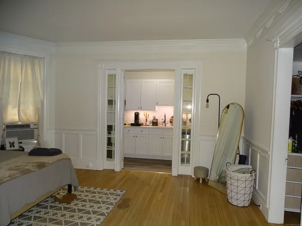 a bedroom with a bed and wooden floor
