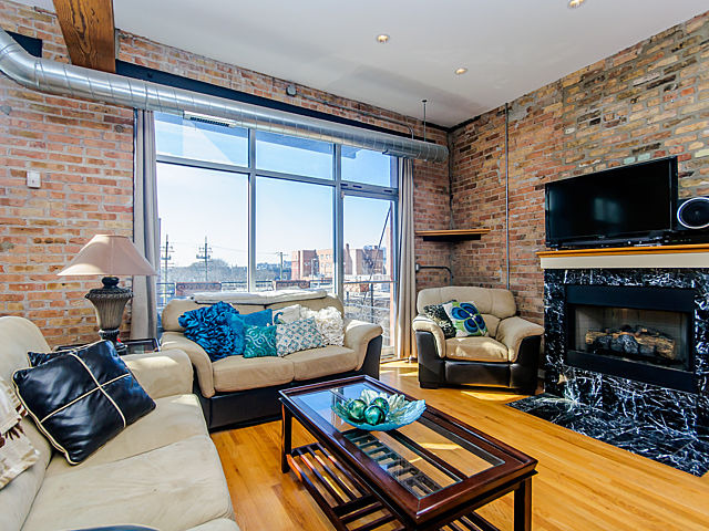 1344 West Madison Street, Unit 303 Chicago, IL 60607 - Photo 2 of 20 a living room with furniture a flat screen tv and a fireplace
