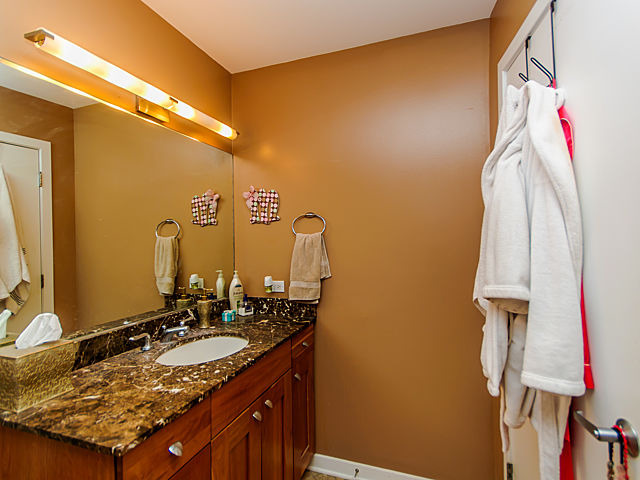 1344 West Madison Street, Unit 303 Chicago, IL 60607 - Photo 12 of 20 a bathroom with a granite countertop sink and a mirror