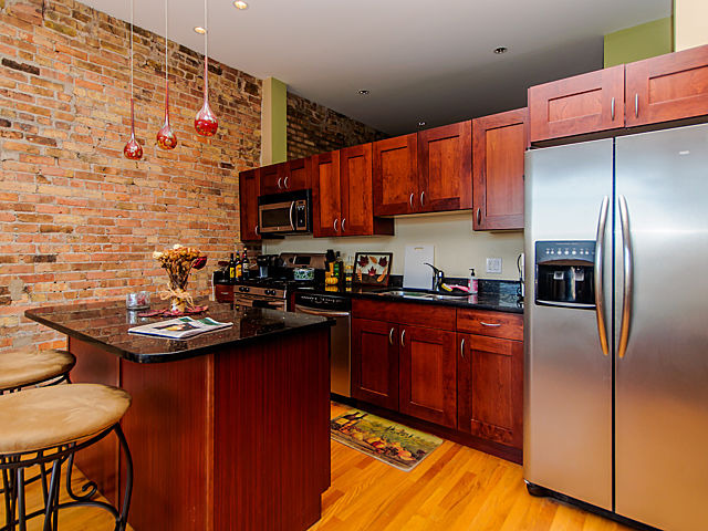 1344 West Madison Street, Unit 303 Chicago, IL 60607 - Photo 7 of 20 a kitchen with stainless steel appliances granite countertop a sink refrigerator and cabinets