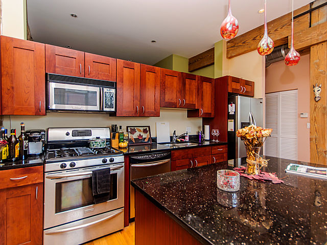 1344 West Madison Street, Unit 303 Chicago, IL 60607 - Photo 8 of 20 a kitchen with stainless steel appliances granite countertop a sink stove and cabinets