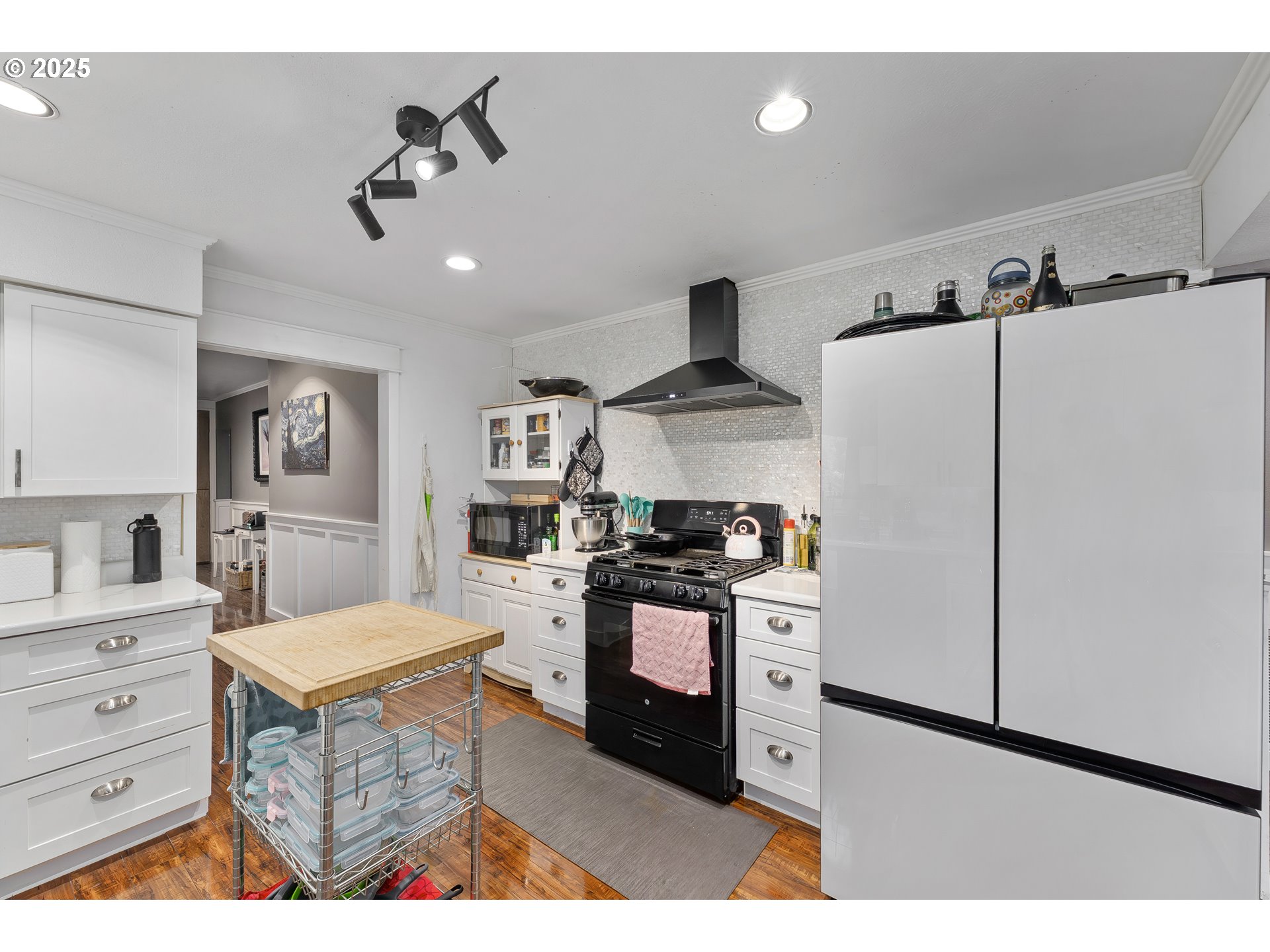 190 Walnut Street Myrtle Creek, OR 97457 - Photo 18 of 48 a kitchen with stainless steel appliances kitchen island granite countertop a refrigerator a stove a sink dishwasher and white cabinets with wooden floor