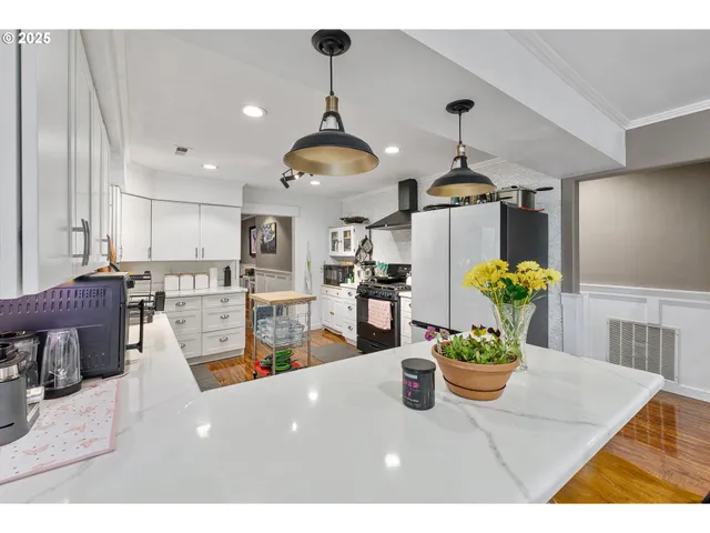 a view of a dining room and livingroom with furniture wooden floor a chandelier