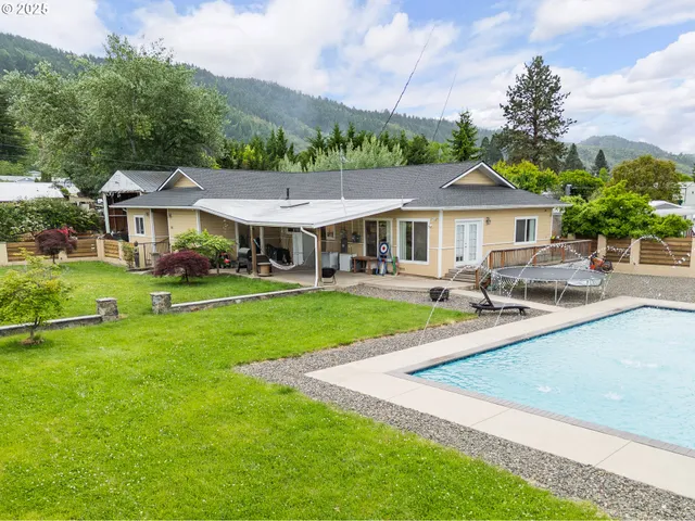 a view of house with garden and tall trees