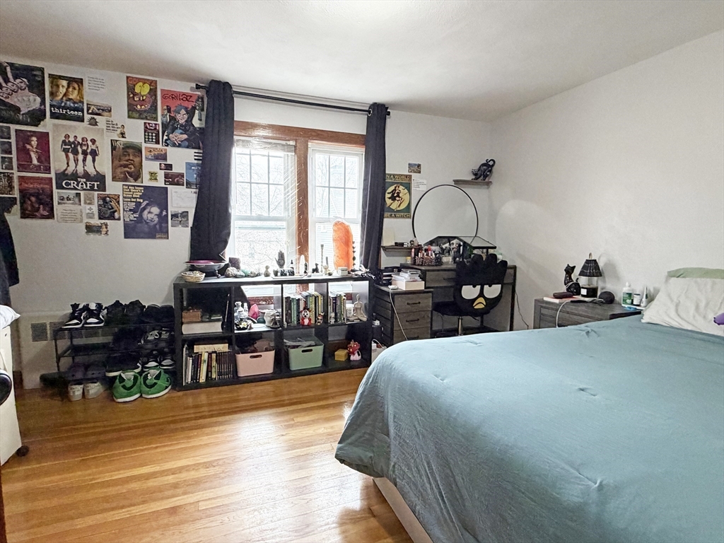 75-77 Dale Street, Unit 77 Waltham, MA 02451 - Photo 14 of 17 a bedroom with a bed a large window and book shelf