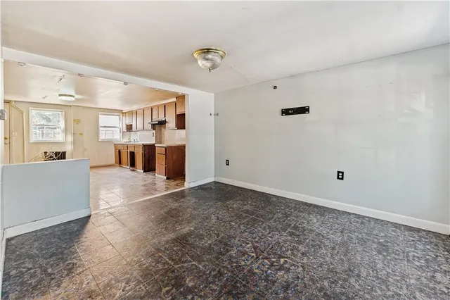 a view of a big room with windows and chandelier fan