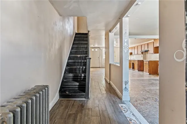 a view of a hallway with wooden floor and staircase