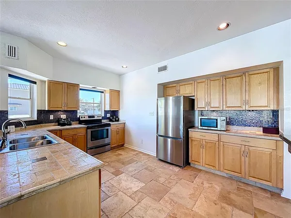 a kitchen with stainless steel appliances granite countertop a sink stove and refrigerator