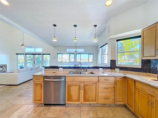 a kitchen with kitchen island granite countertop a sink stove and cabinets