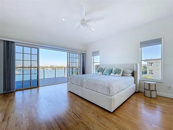 a spacious bedroom with a large bed and a wooden floor