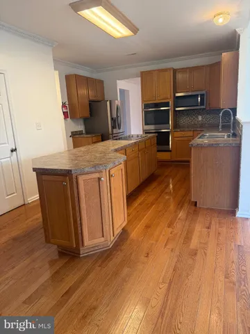 a kitchen with wooden floors and wooden cabinets