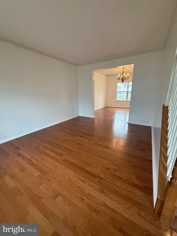 a view of empty room with window and wooden floor