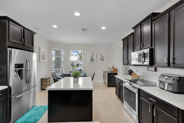 a kitchen with stainless steel appliances granite countertop a sink refrigerator and microwave