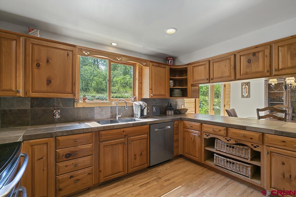 154 N Road Durango, CO 81303 - Photo 6 of 35 a kitchen with stainless steel appliances granite countertop a sink a stove cabinets and wooden floor