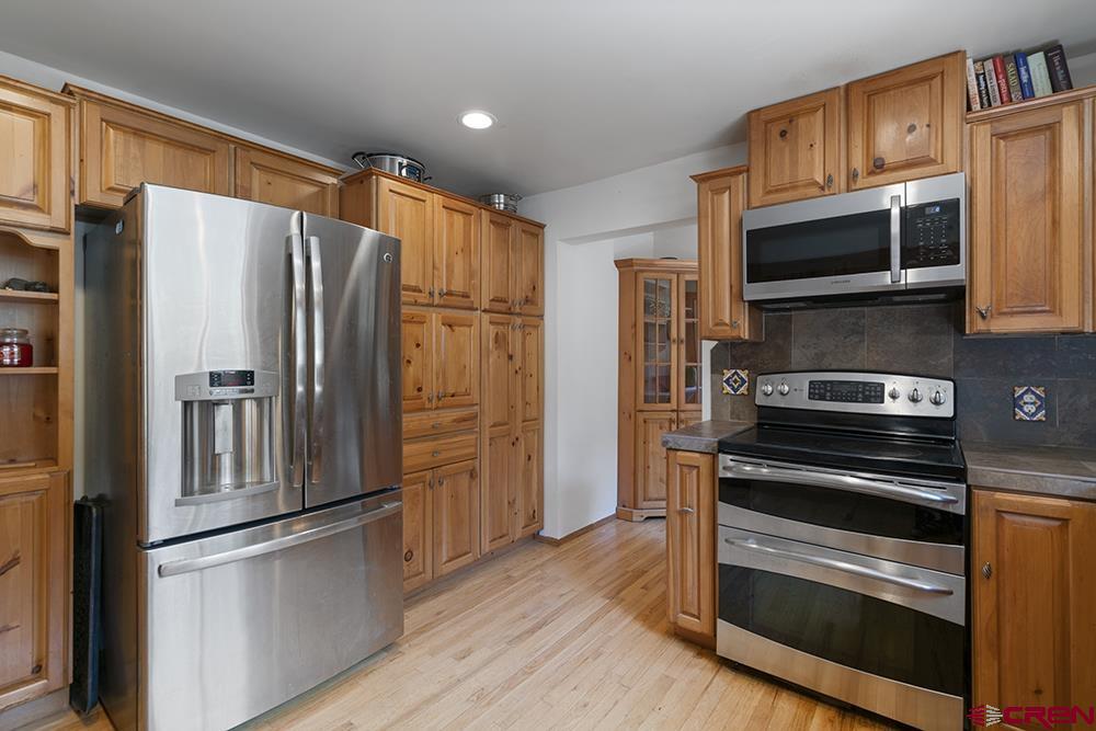 154 N Road Durango, CO 81303 - Photo 7 of 35 a kitchen with stainless steel appliances and wooden cabinets
