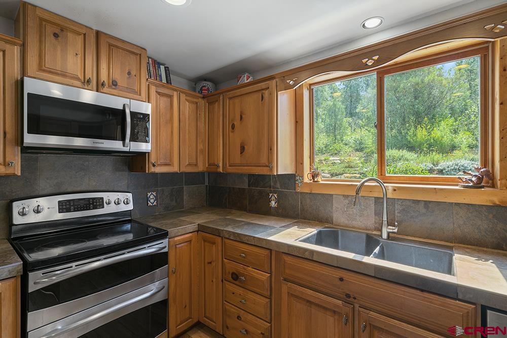 154 N Road Durango, CO 81303 - Photo 8 of 35 a kitchen with stainless steel appliances a sink a stove and cabinets