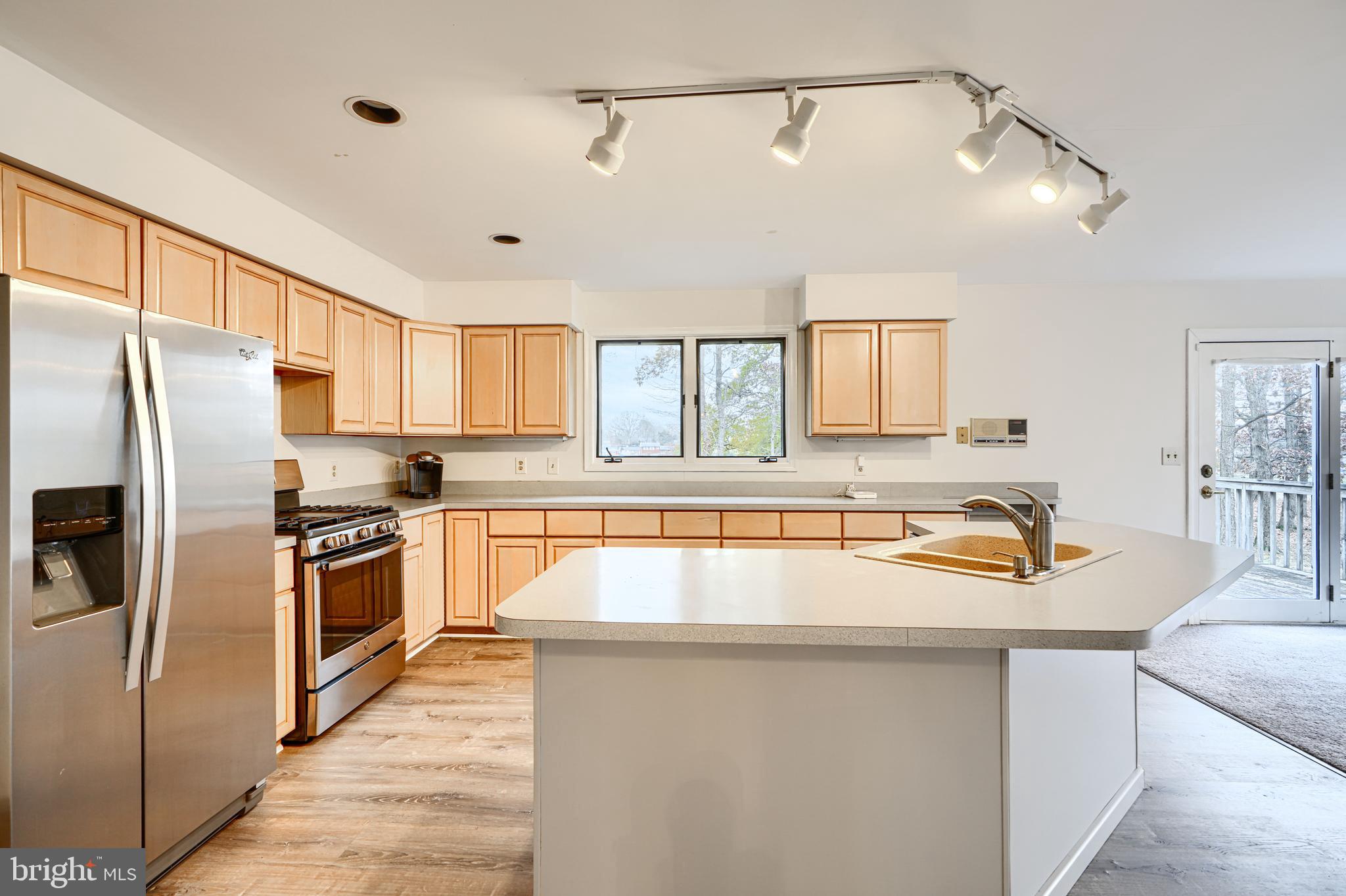 2508 Perring Woods Road Baltimore, MD 21234 - Photo 13 of 42 a kitchen with granite countertop a center island stainless steel appliances a refrigerator cabinets and a window