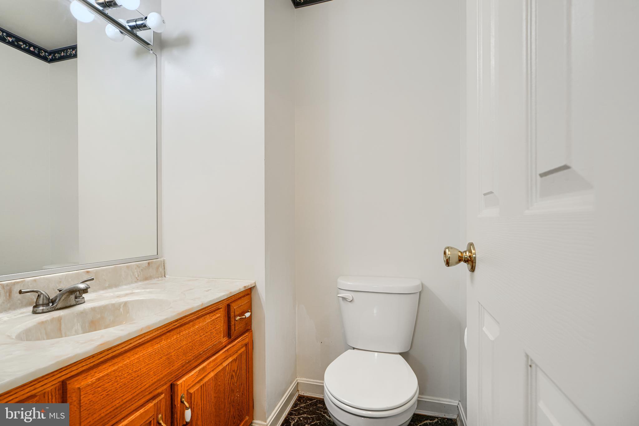 2508 Perring Woods Road Baltimore, MD 21234 - Photo 6 of 42 a bathroom with a toilet sink and mirror