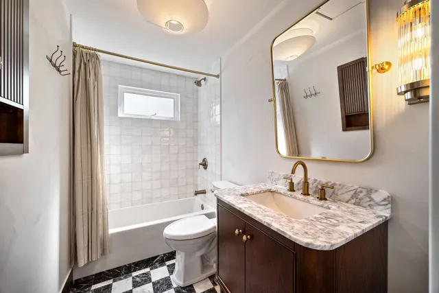 a bathroom with a granite countertop sink toilet and shower