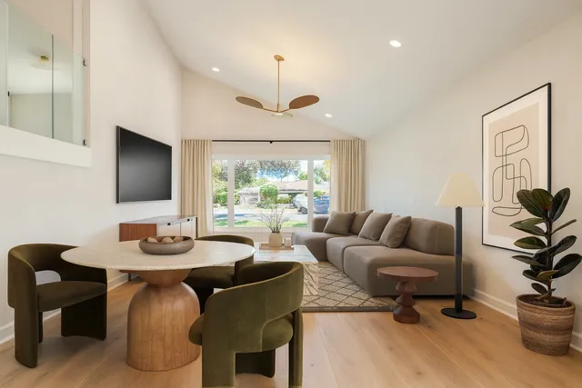 a living room with furniture a window and a flat screen tv