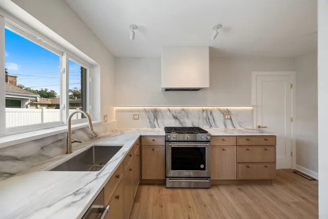 a kitchen with a stove sink and cabinets