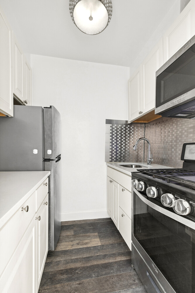 330 East 80th Street, Unit 3K Manhattan, NY 10075 - Photo 4 of 8 a kitchen with stainless steel appliances granite countertop a stove and a microwave
