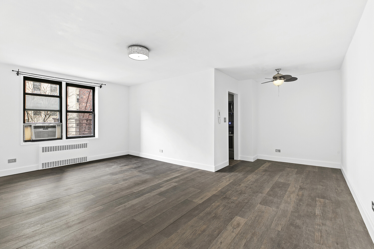 330 East 80th Street, Unit 3K Manhattan, NY 10075 - Photo 7 of 8 an empty room with wooden floor and windows