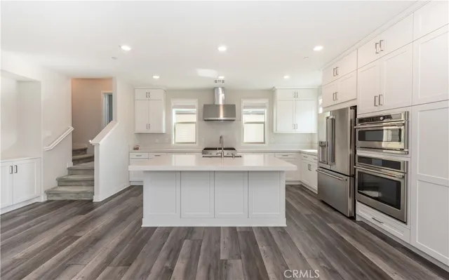 a kitchen with stainless steel appliances a refrigerator sink and stove