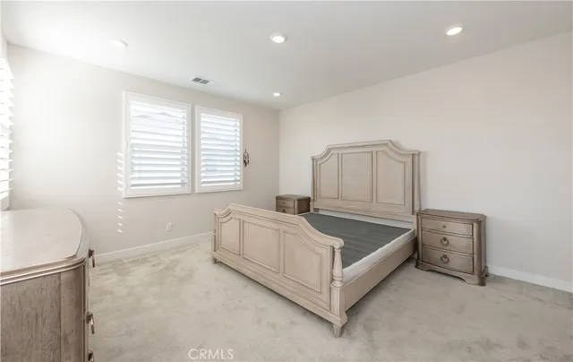 a spacious bedroom with a bed and a window