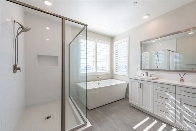 a spacious bathroom with a tub sink shower and mirror