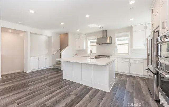 a open kitchen with white cabinets and stainless steel appliances
